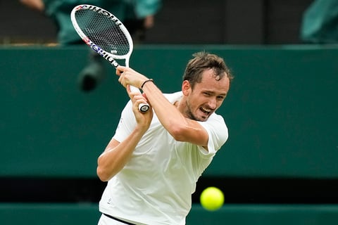 Daniil Medvedev plays a backhand return to Jannik Sinner